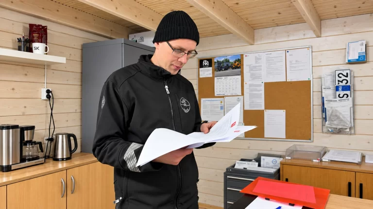 SK Katsastuksen työntekijä tarkastaa ajoneuvon asiakirjoja.